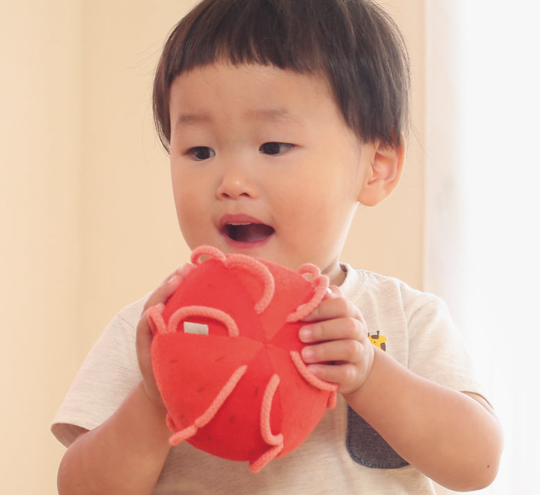 両手にわっかボールりんごを抱える子供